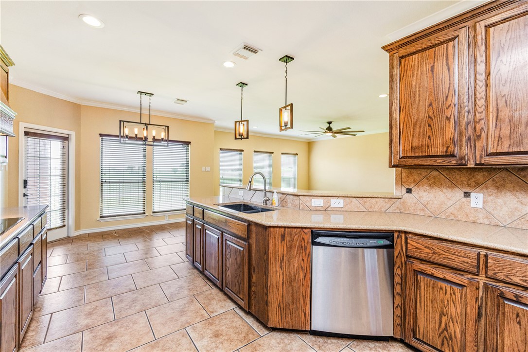 307 Heathercrest Portland, TX 78374 - Photo 9 of 40 a kitchen with stainless steel appliances granite countertop a sink a stove and a wooden cabinets