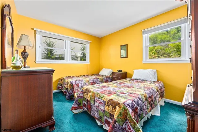 a bedroom with 2 bed and a window