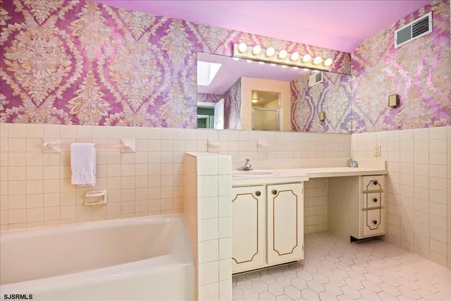 a bathroom with a sink mirror and a bath tub