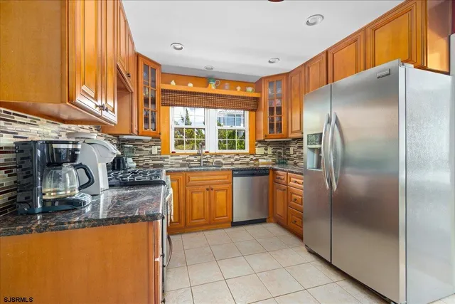 a kitchen with stainless steel appliances granite countertop a refrigerator and a sink