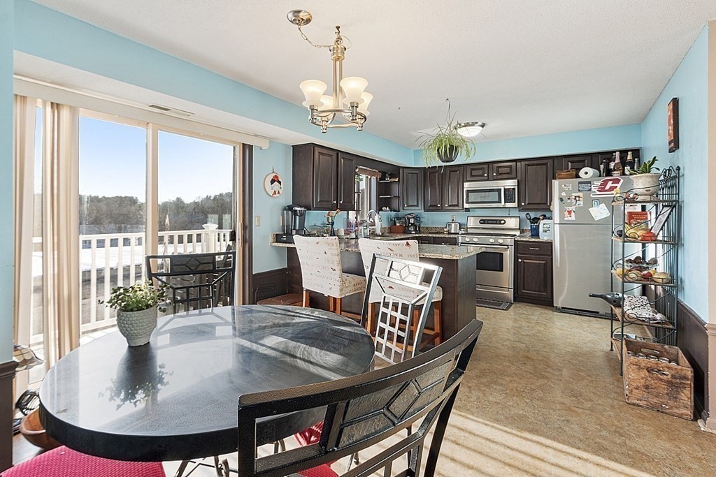 84 Century Way, Unit 84 Gardner, MA 01440 - Photo 11 of 28 a dining table chairs and a kitchen view