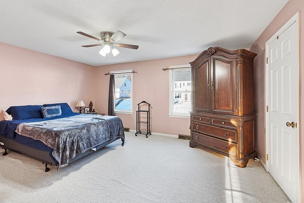 84 Century Way, Unit 84 Gardner, MA 01440 - Photo 21 of 28 a bedroom with a bed and a chandelier