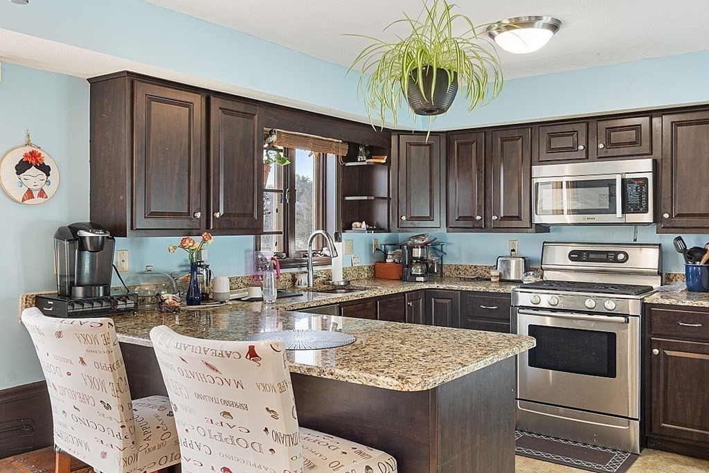 84 Century Way, Unit 84 Gardner, MA 01440 - Photo 5 of 28 a kitchen with stainless steel appliances granite countertop a sink a stove and a microwave
