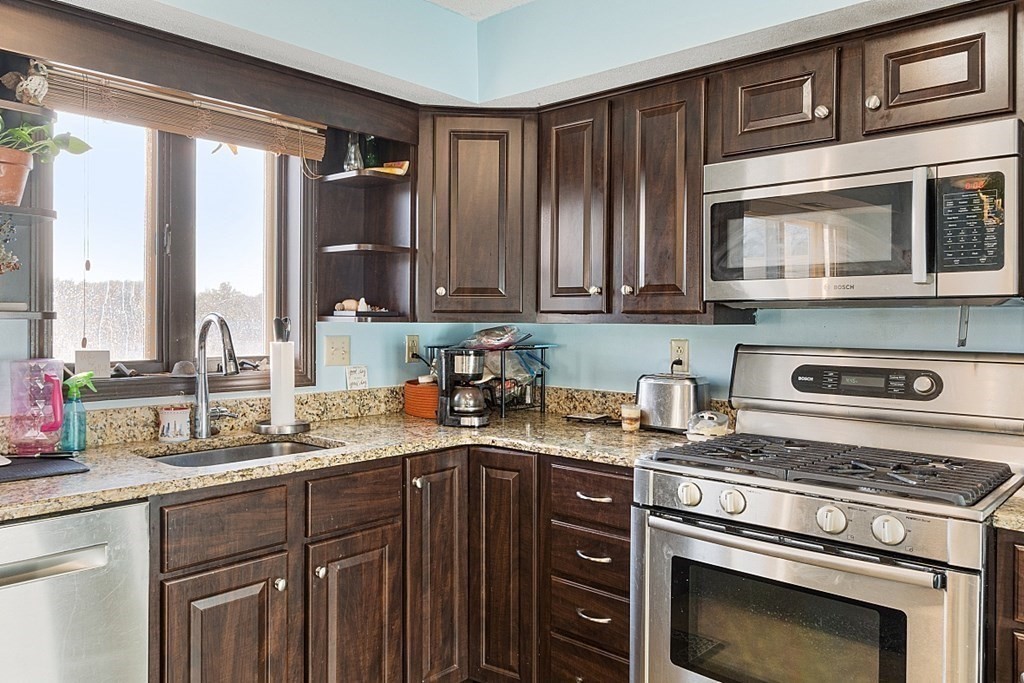 84 Century Way, Unit 84 Gardner, MA 01440 - Photo 8 of 28 a kitchen with stainless steel appliances granite countertop a stove a sink and a microwave