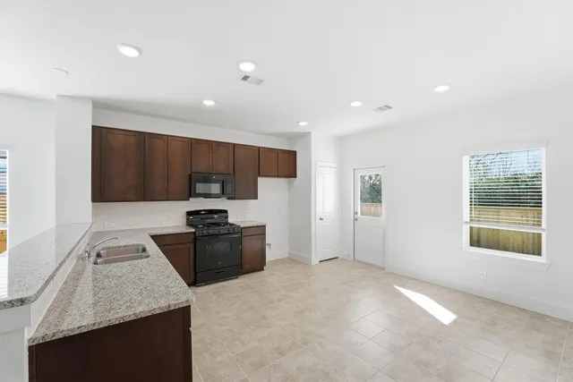 a kitchen with stainless steel appliances granite countertop a sink stove and refrigerator