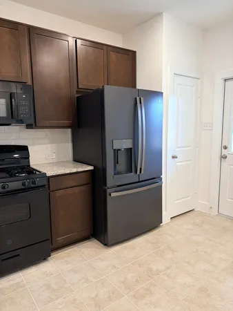 a kitchen with stainless steel appliances granite countertop a refrigerator and a stove