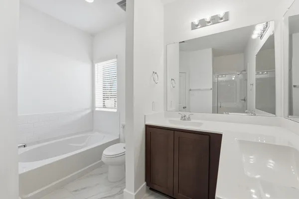 a bathroom with a granite countertop sink a toilet and bathtub