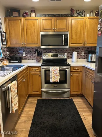 a kitchen with stainless steel appliances a stove a sink and a microwave