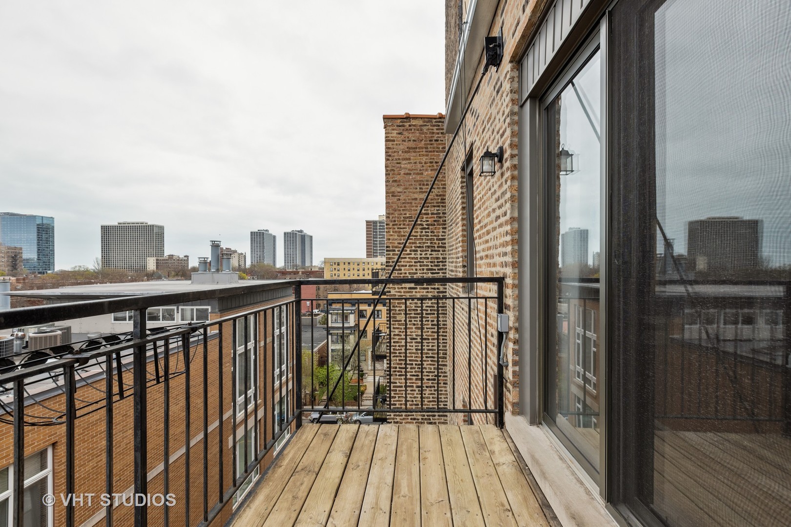 4144 North Sheridan Road, Unit 609 Chicago, IL 60613 - Photo 14 of 17 a view of a balcony with wooden floor and fence