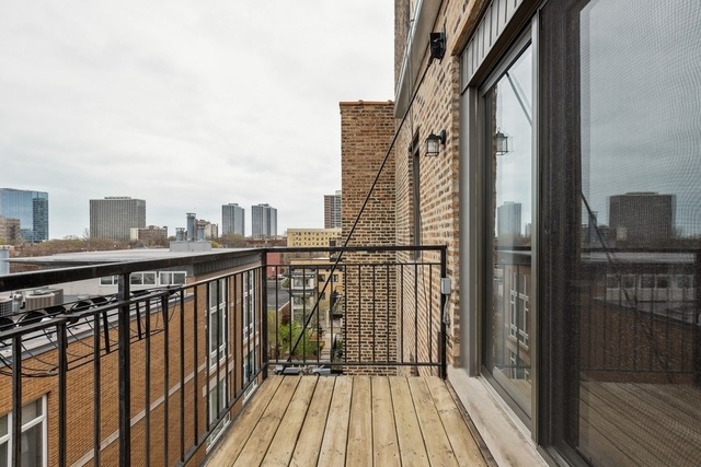 4144 North Sheridan Road, Unit 609 Chicago, IL 60613 - Photo 17 of 17 a view of a balcony with wooden floor and fence