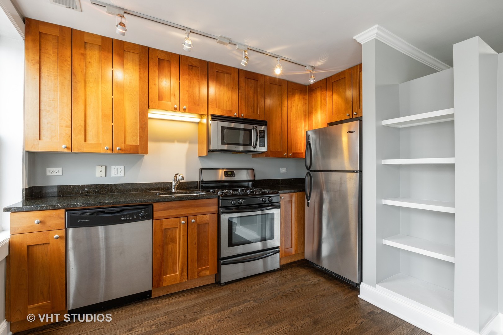 4144 North Sheridan Road, Unit 609 Chicago, IL 60613 - Photo 8 of 17 a kitchen with stainless steel appliances granite countertop a stove a refrigerator and a microwave