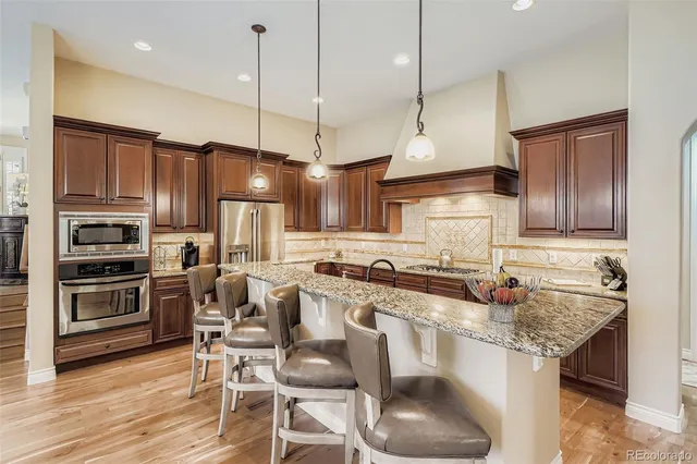 a kitchen with stainless steel appliances granite countertop a stove refrigerator and cabinets