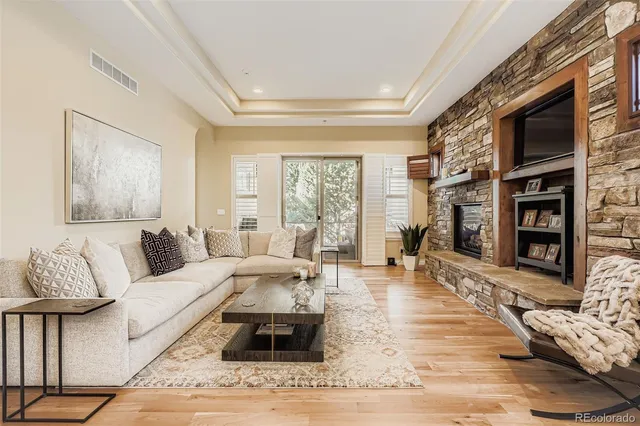 a living room with furniture large window and wooden floor