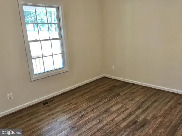 a view of a room with wooden floor and window