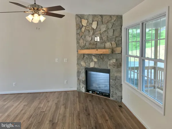 wooden floor fireplace and windows in an empty room