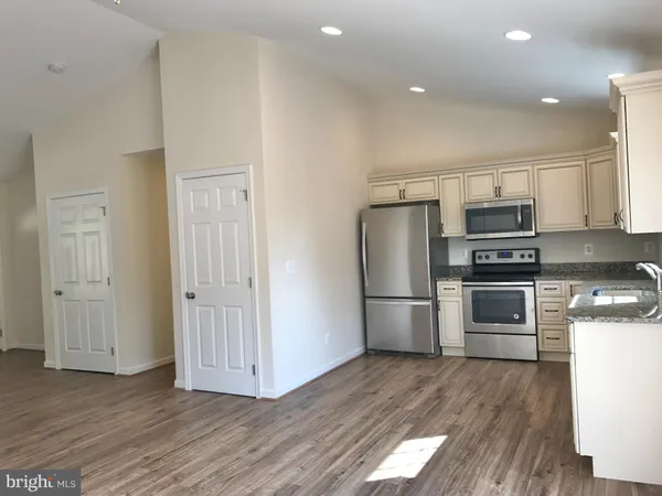 a kitchen with granite countertop a refrigerator and a stove top oven