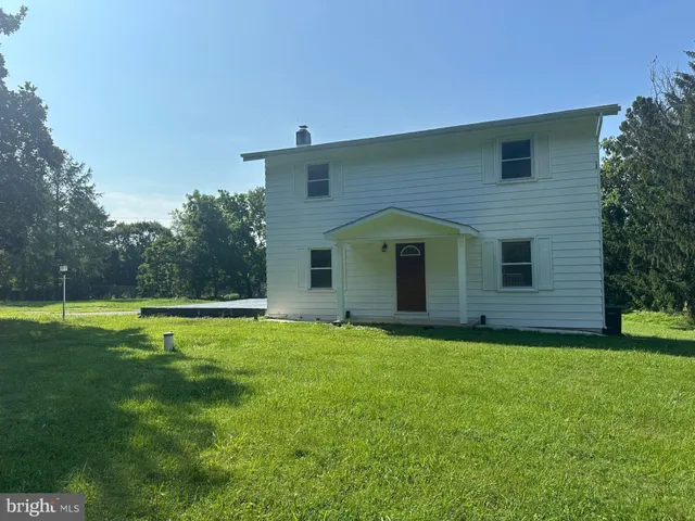 a view of a house with a yard and a house