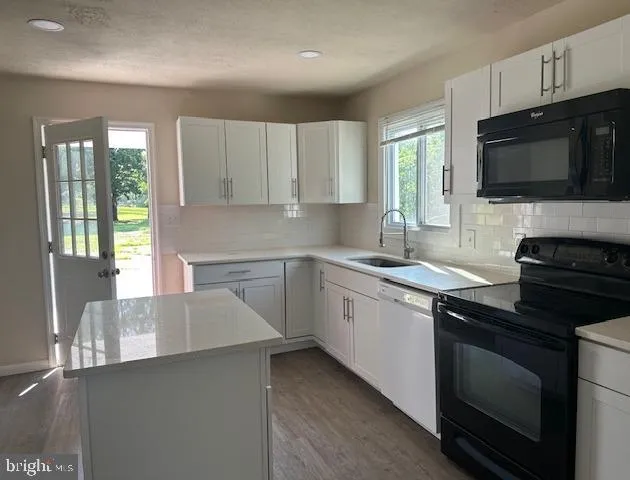 a kitchen with a sink a microwave and cabinets