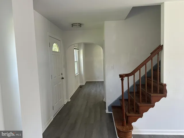a view of a hallway with wooden floor and staircase