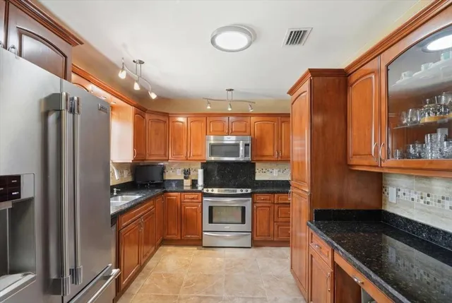 a kitchen with stainless steel appliances granite countertop a stove and a refrigerator