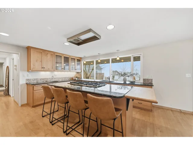a kitchen with kitchen island a counter top space a sink stainless steel appliances and cabinets