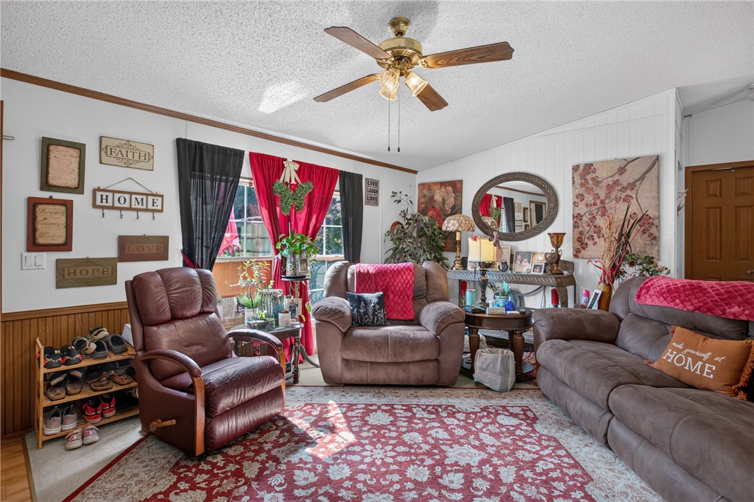 418 Chauga Road Westminster, SC 29693 - Photo 3 of 38 Comfortable living area offers a ceiling fan, plush seating, and rich wood flooring.