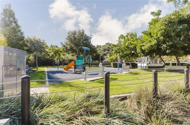 a view of a swimming pool with a bench and trees around