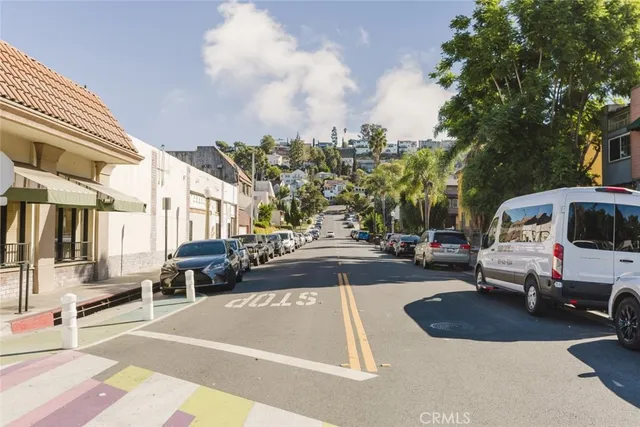 a view of a city street lined with parked cars