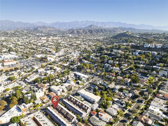 an aerial view of residential houses with outdoor space and trees