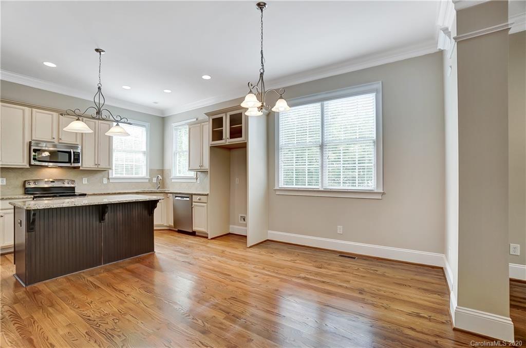 718 Revival Row Fort Mill, SC 29708 - Photo 22 of 47 a kitchen with stainless steel appliances granite countertop a refrigerator a sink dishwasher a stove and white cabinets with wooden floor