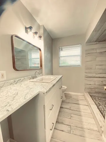 a bathroom with a granite countertop sink a mirror and a