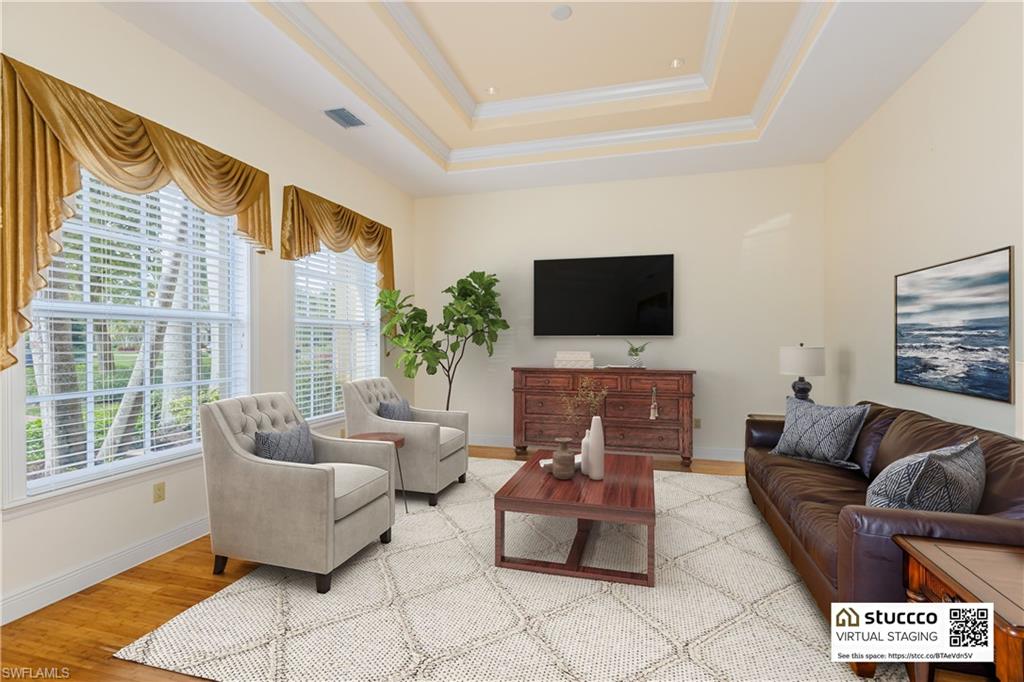 19930 Markward Crossing Estero, FL 33928 - Photo 7 of 40 Living room featuring wood-type flooring and a tray ceiling