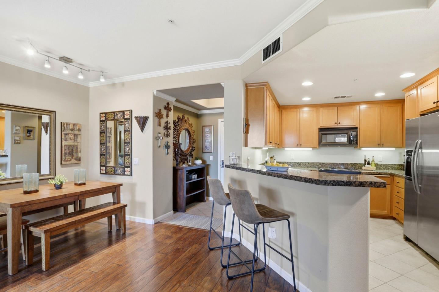 1310 Saddle Rack Street, Unit 314 San Jose, CA 95126 - Photo 7 of 43 a kitchen with stainless steel appliances granite countertop a stove top oven a sink dishwasher a dining table and chairs with wooden floor