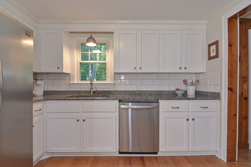 53 Warren Street Upton, MA 01568 - Photo 13 of 41 a kitchen with granite countertop white cabinets and window