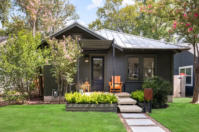 a front view of a house with a yard and potted plants
