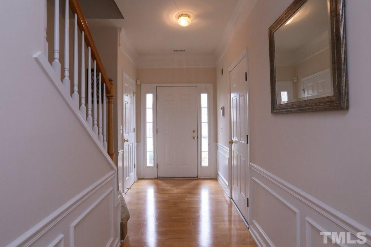 7113 Lovko Lane Raleigh, NC 27613 - Photo 11 of 25 a view of a hallway with wooden floor and staircase
