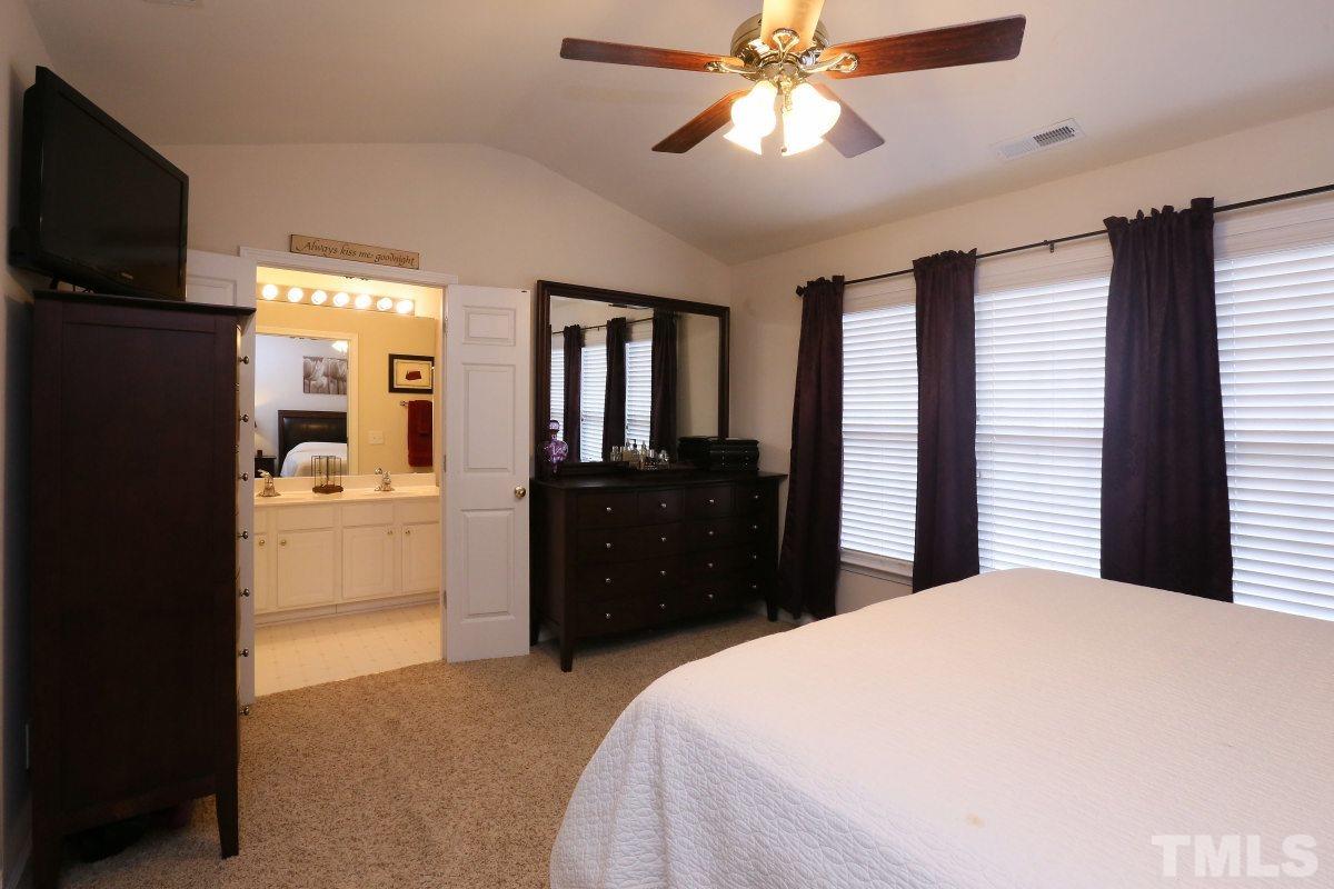 7113 Lovko Lane Raleigh, NC 27613 - Photo 14 of 25 a bedroom with a bed and a flat tv screen