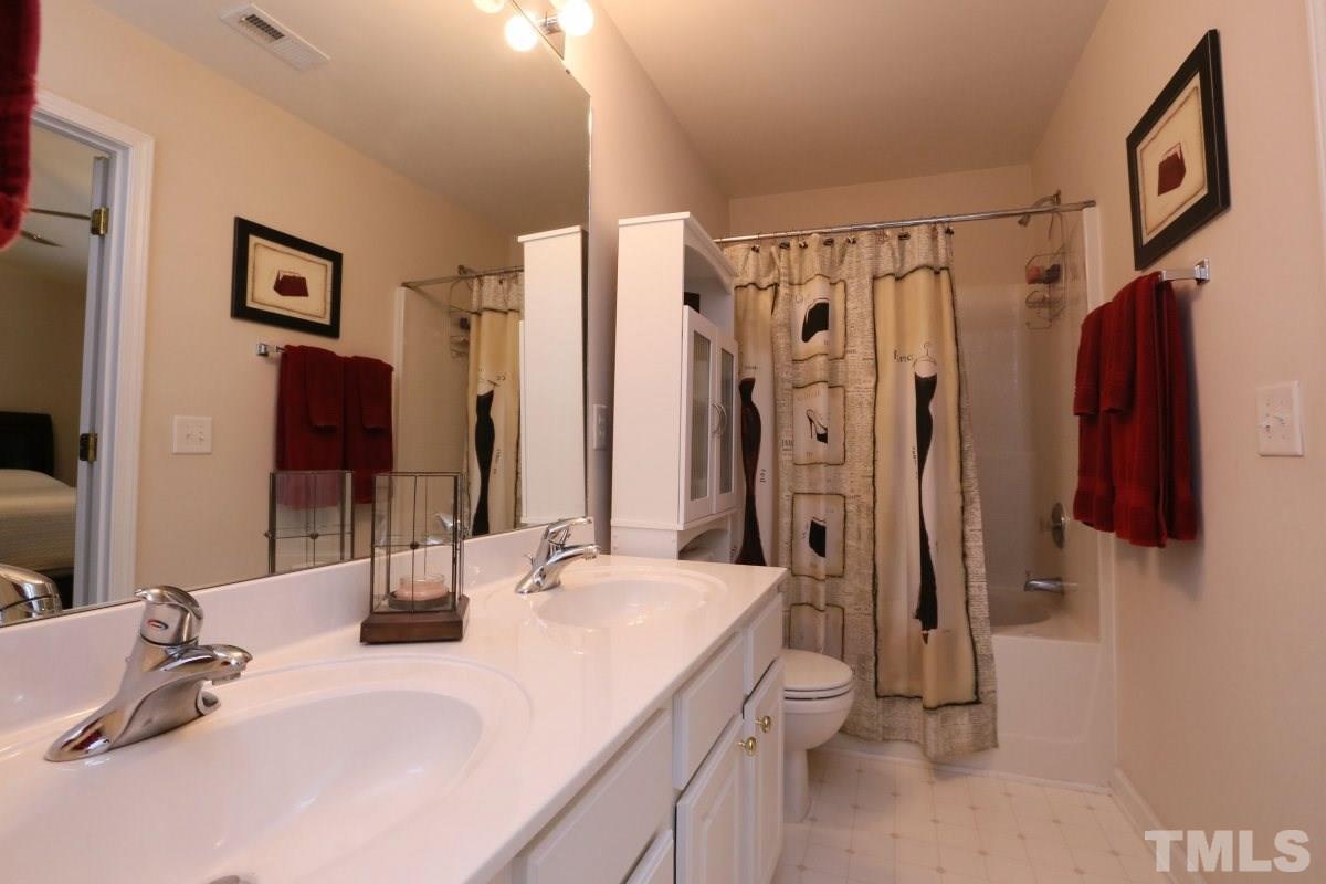 7113 Lovko Lane Raleigh, NC 27613 - Photo 15 of 25 a bathroom with a double vanity sink mirror and shower