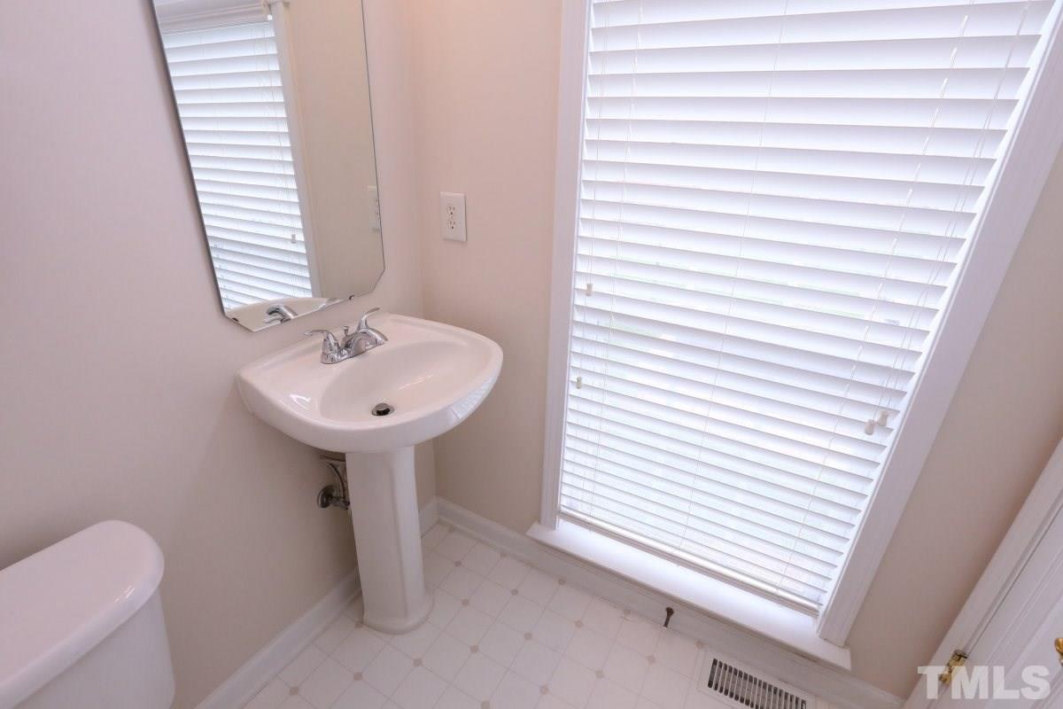 7113 Lovko Lane Raleigh, NC 27613 - Photo 19 of 25 a bathroom with a sink a toilet and a mirror