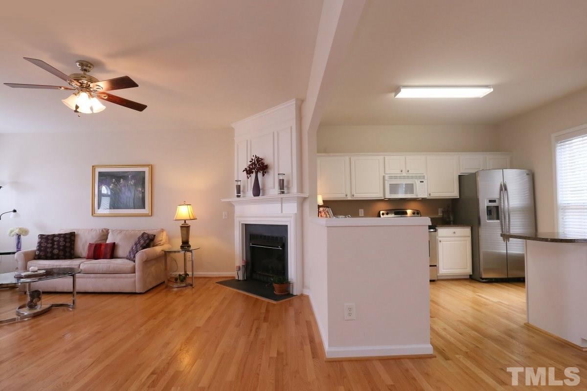 7113 Lovko Lane Raleigh, NC 27613 - Photo 5 of 25 a living room with stainless steel appliances furniture a fireplace and a book shelf