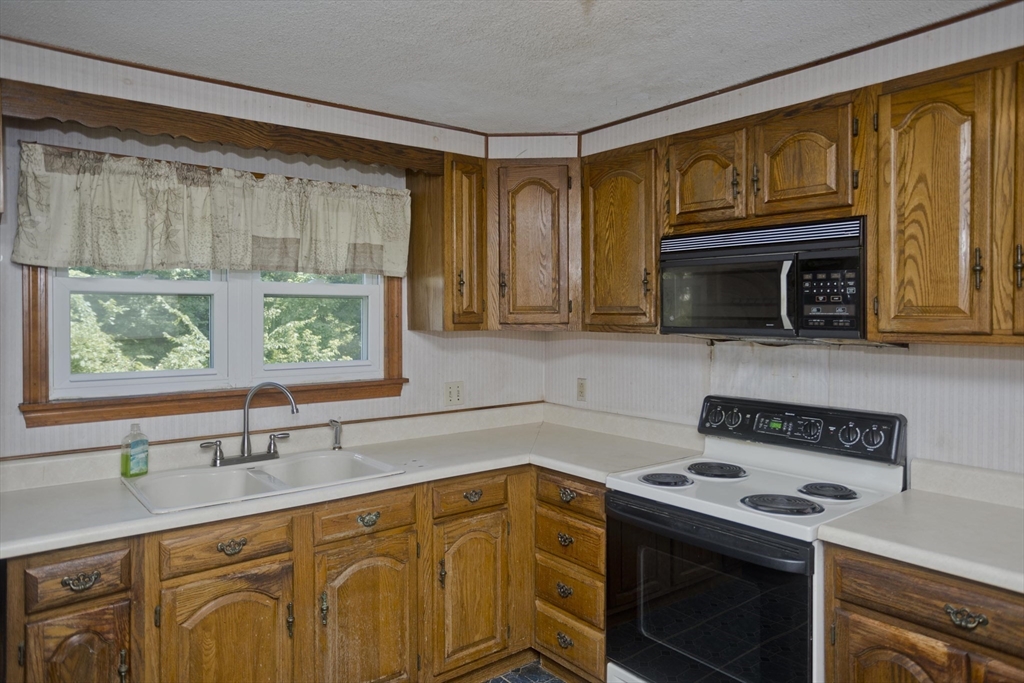 21 Bremen Street Springfield, MA 01108 - Photo 8 of 40 a kitchen with stainless steel appliances a stove a sink and a microwave