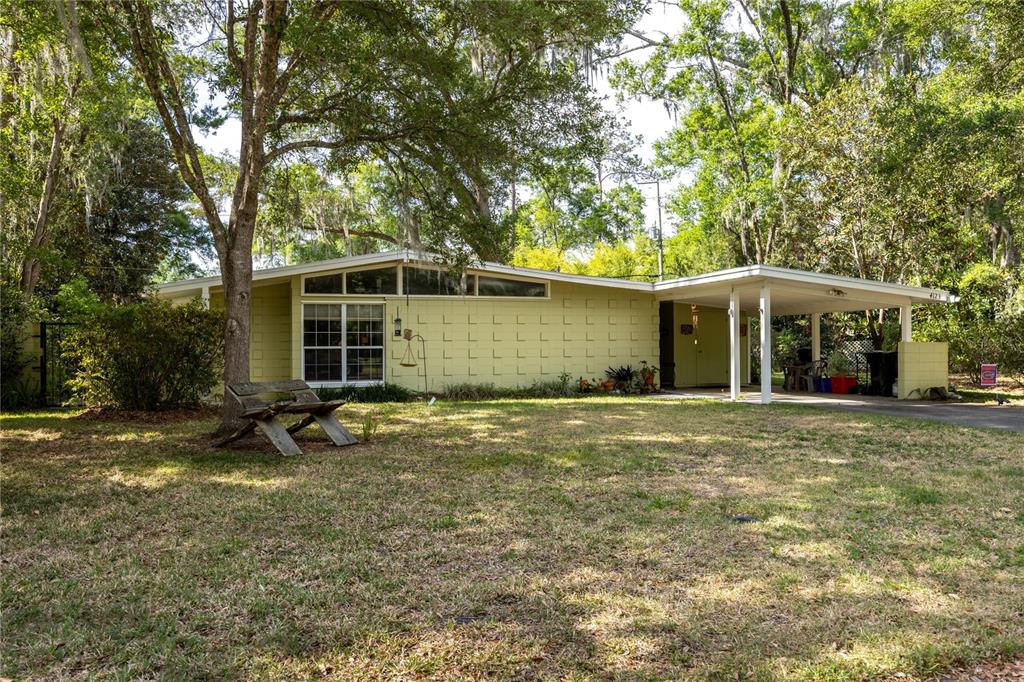 4123 Northwest 18th Place Gainesville, FL 32605 - Photo 1 of 36 a backyard of a house with table and chairs