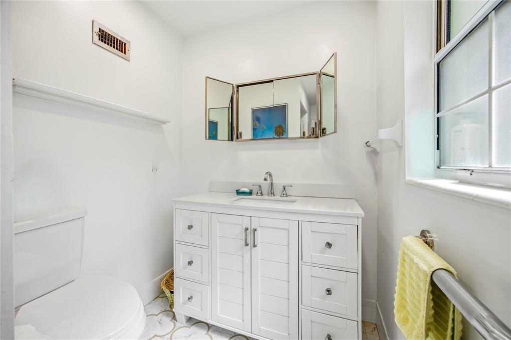 4123 Northwest 18th Place Gainesville, FL 32605 - Photo 23 of 36 a bathroom with a granite countertop toilet sink and mirror