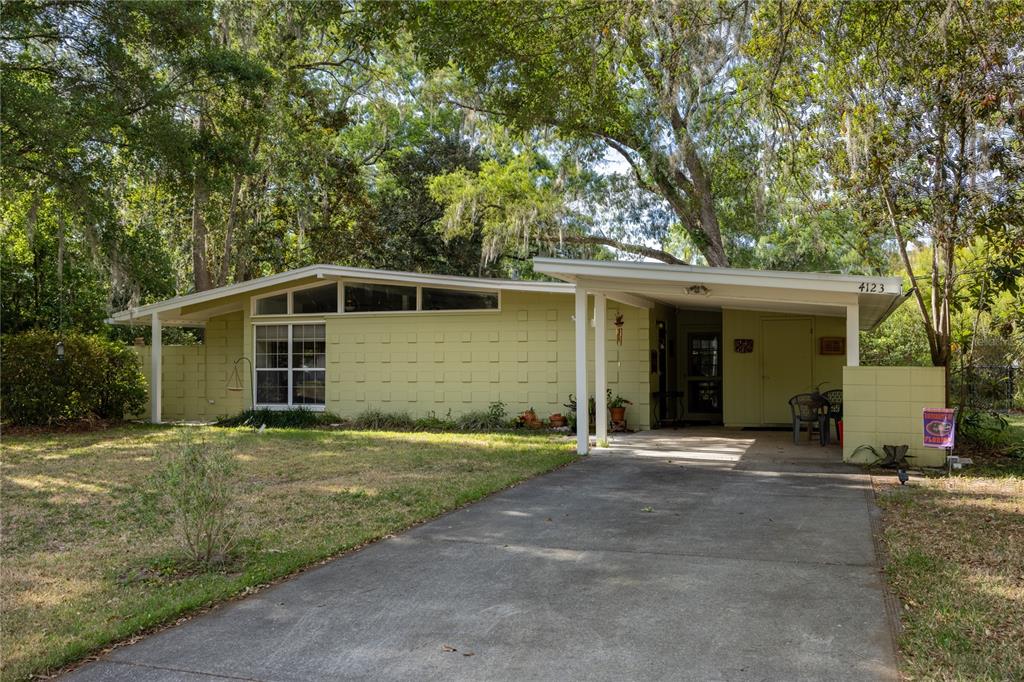 4123 Northwest 18th Place Gainesville, FL 32605 - Photo 28 of 36 a front view of a house with a yard and garage