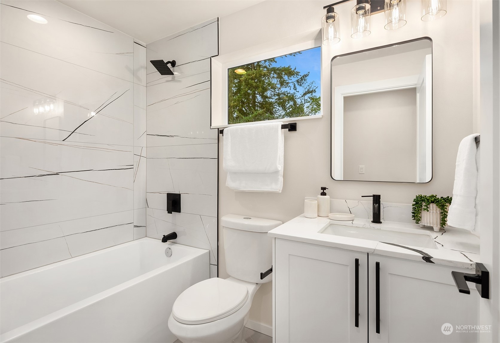 3234 Northeast 88th Street Seattle, WA 98115 - Photo 21 of 23 a bathroom with a sink a toilet a mirror a vanity and bathtub