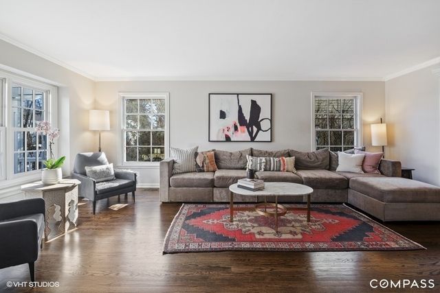 a living room with furniture a rug and a large window