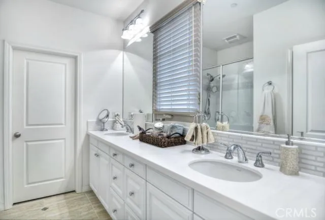 a bathroom with double vanity sinks and a mirror