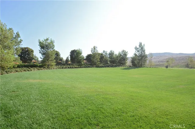 a view of a green field with wooden fence