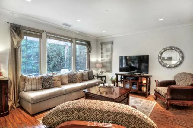 a living room with furniture a flat screen tv and a large window