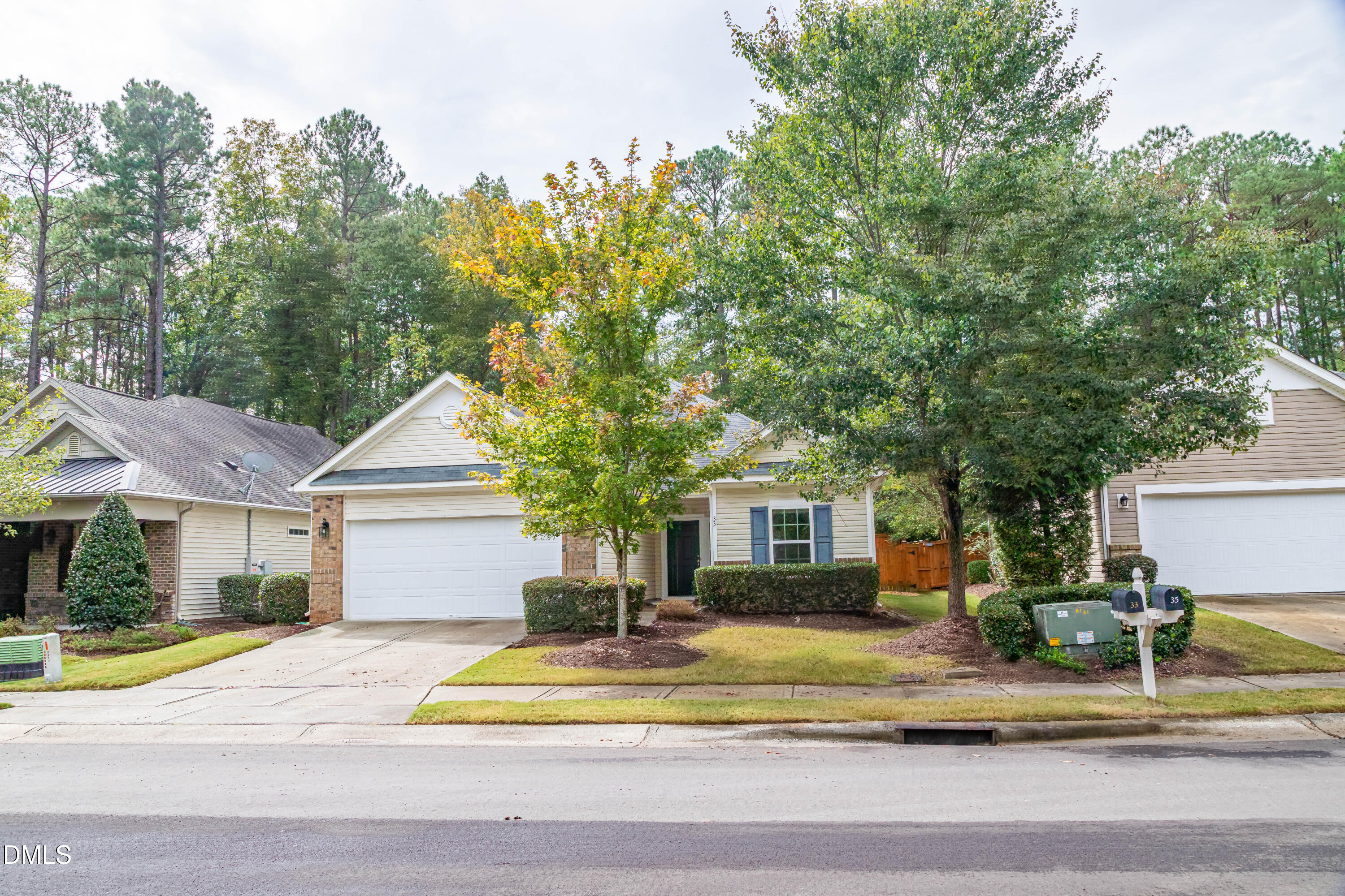 33 Juliette Drive Durham, NC 27713 - Photo 4 of 39 a view of a white house with a small yard and large trees